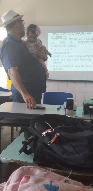 Professor Emanuel Tenório com o filho de uma aluna do EJAI para que ela pudesse assistir a aula. Foto: arquivo pessoal