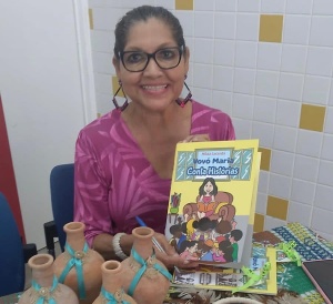 Professora e escritora Hilda Maria com seu livro "Vovó Maria Conta Histórias”. Foto: cortesia.