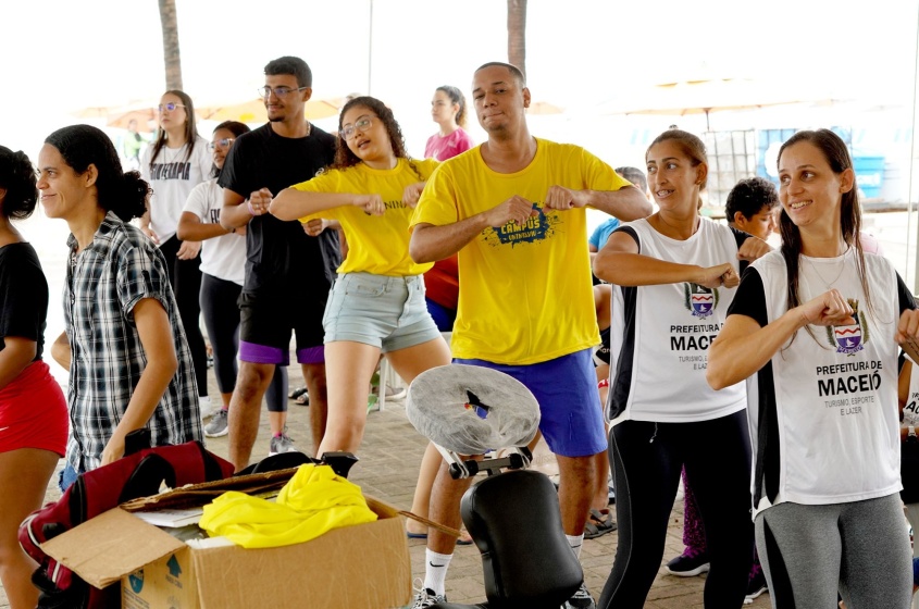 Jailson Junior e Gabriele Nascimento, de amarelos, coordenador e aluna do curso de fisioterapia da Uninassau que presta serviço no Praia Acessível. Eles aproveitaram aula de dança. Foto: Émile Valões / Ascom Semtel