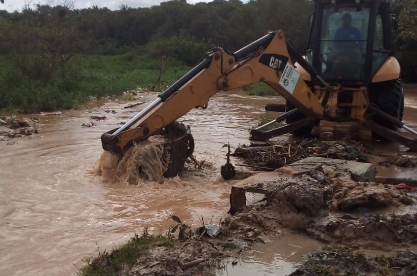 Com o uso de uma máquina retroescavadeira, agentes fazem a retirada do barro alojado no canal. Foto: Ascom Sudes