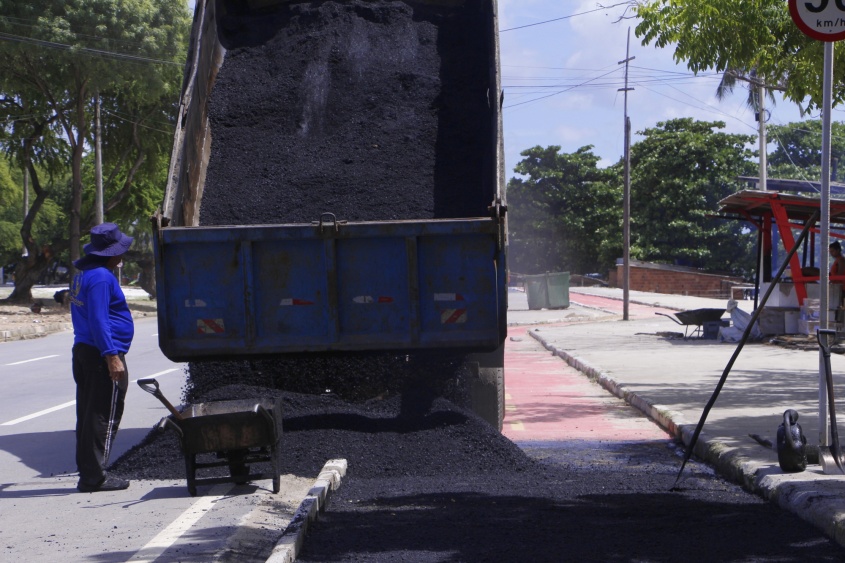 Caminhão descarregando asfalto em trecho do Dique Estrada, no Vergel do Lago. Foto: Wilma Andrade/Ascom Seminfra