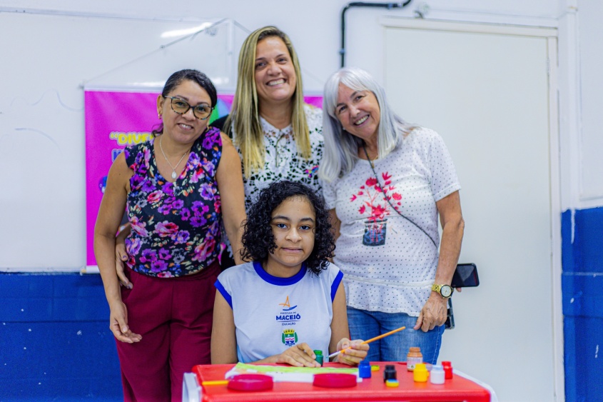 Estudante com a mãe, a professora e a técnica da Semed. Foto: Carol Cordeiro/ Ascom Semed