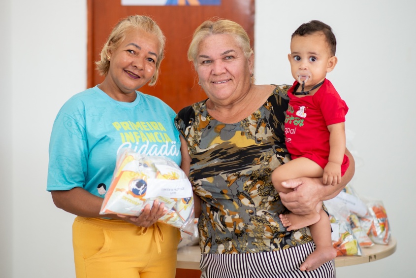 Pyetro Miguel, de 1 ano e 8 meses, com a sua avô recebendo o kit. Foto:Secom Maceió