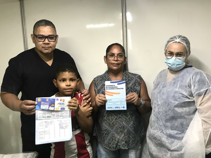 Pequeno Igor e Dona Flaviana exibindo a caderneta de vacinação. Foto: Ascom Segov