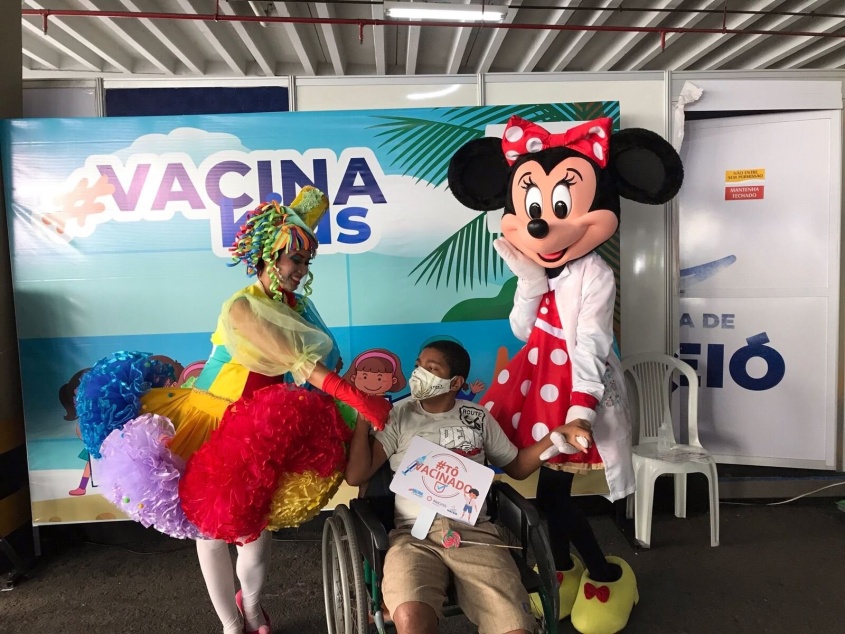 Ian Alessandro, neto de Maria de Lurdes, posando no mural após a vacinação. Foto: Ascom SMS